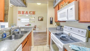 A kitchen with granite countertops, stainless steel appliances, and wooden cabinets.