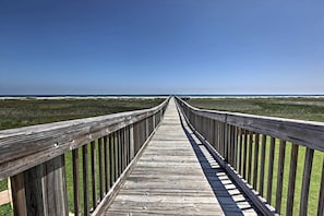 A wooden boardwalk leading to a beach with a clear sky. - Breezy Galveston House w/ 2 Decks & Ocean Views! (Galveston)