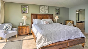 A neatly arranged bedroom with a large bed, a chair, a nightstand, and a dresser. - Idyllic PCB Condo w/ Pool Access & Ocean Views! (Panama City Beach)
