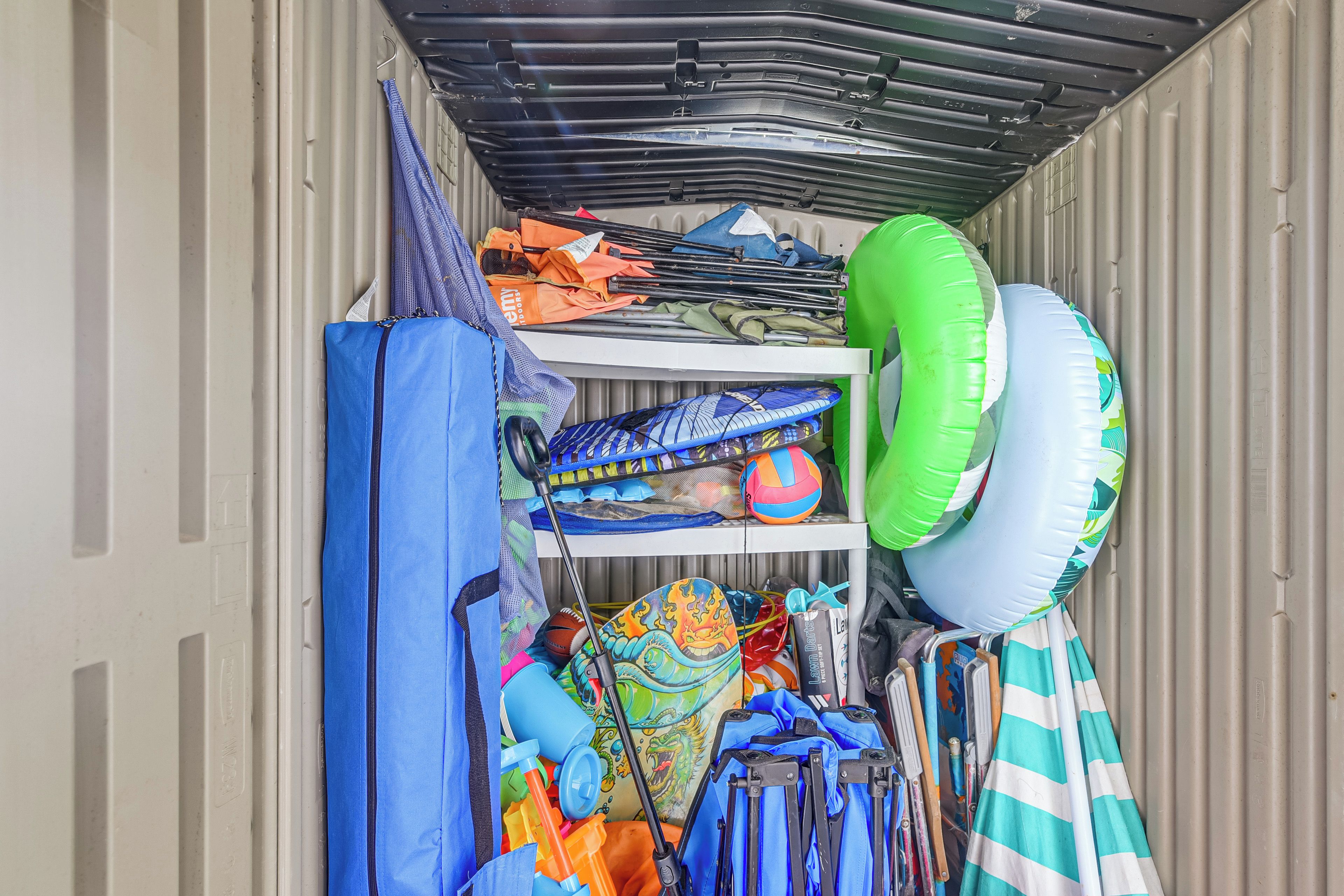 A storage area with various items including a blue bag, sports equipment, and inflatable rings.