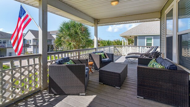 A covered outdoor seating area with wicker furniture and a view of neighboring houses. - Walk to Galveston Beach: Coastal Escape w/ Yard (Galveston)
