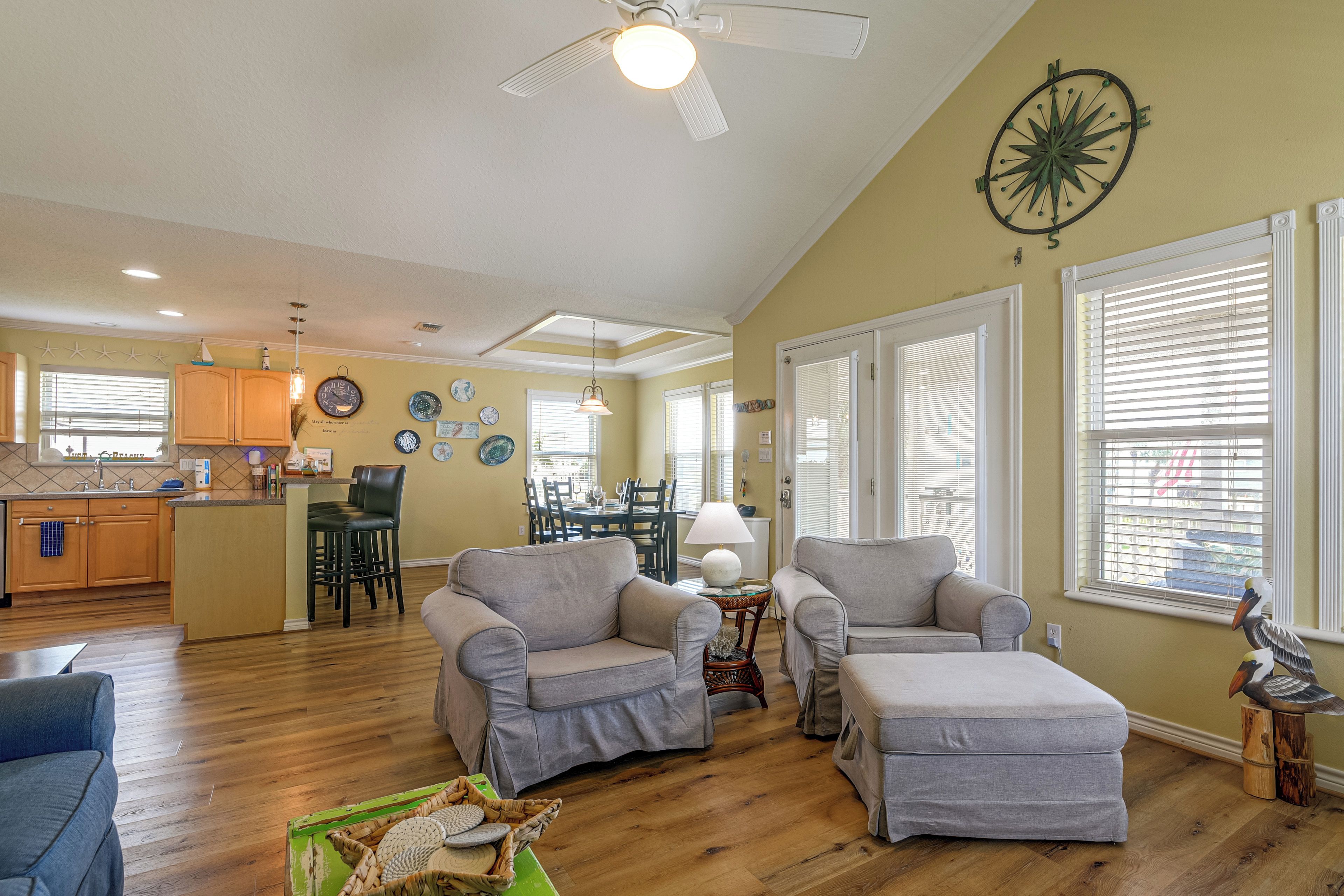 A spacious living area with a dining table, two sofas, and a kitchen in the background.
