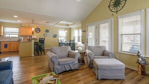 A spacious living area with a dining table, two sofas, and a kitchen in the background. - Walk to Galveston Beach: Coastal Escape w/ Yard (Galveston)