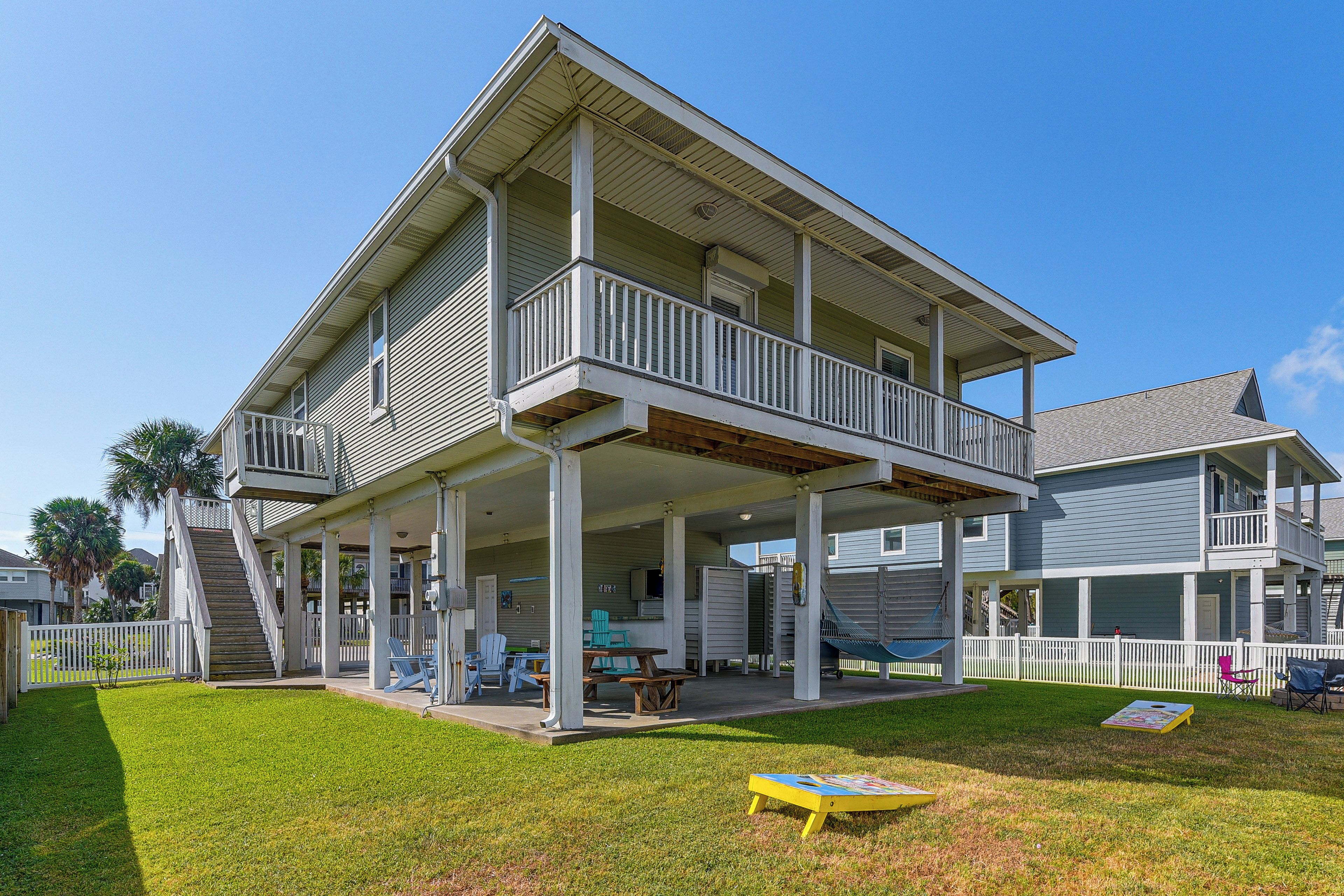 A two-story house with a covered porch and a small deck.