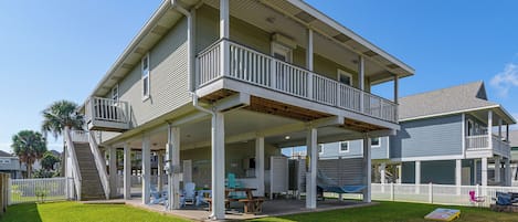 A two-story house with a covered porch and a small deck.