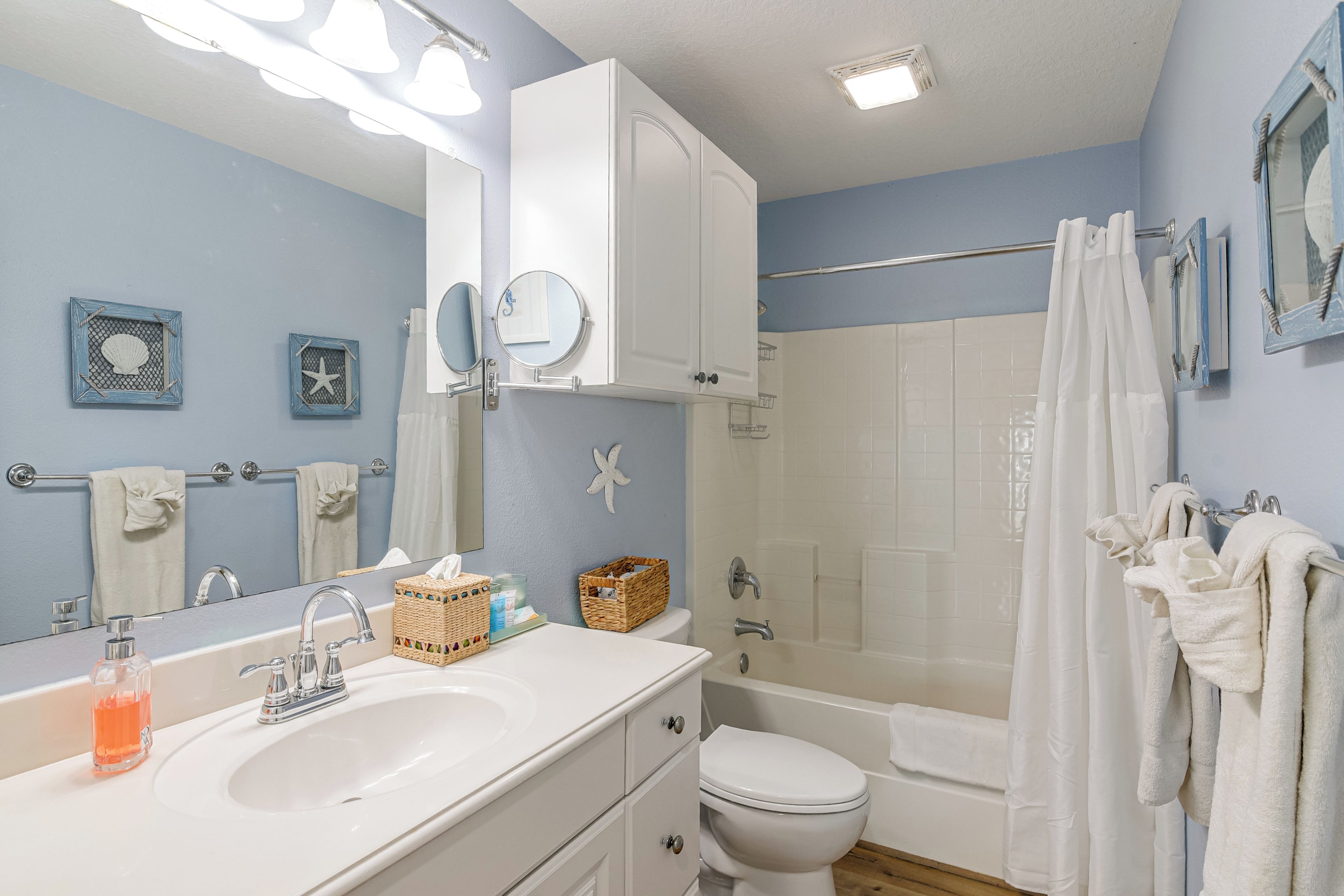 Une salle de bain équipée d’un lavabo, d’un miroir, de toilettes et d’une douche.