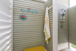 Ein Badezimmer mit einem an der Wand hängenden Handtuch, einer Duschbrause und einem Schild mit der Aufschrift 'TO LIFE BOATS'.