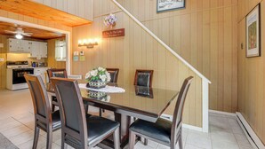 A dining area with a glass table, wooden chairs, and a staircase leading to another level. - Near Hiking & Skiing: Home in Wilmington! (Wilmington)