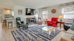 A living room with a television, a red armchair, a green armchair, a blue and white rug, and a small table with a lamp. - Families w/ Pets! Home 4 Mi to Ocean City Beach (Berlin)