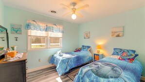 A bedroom with two beds, a ceiling fan, a window with curtains, a desk with a lamp, and artwork on the walls. - Families w/ Pets! Home 4 Mi to Ocean City Beach (Berlin)
