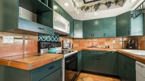 A kitchen with teal cabinets, a microwave, a stove, and a dishwasher. - 2Bed/2Bath Villa by Golf Course (Lake Worth)
