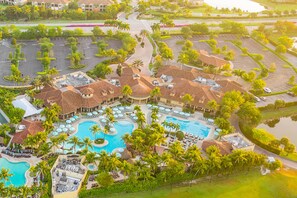 An aerial view of a resort with multiple swimming pools, palm trees, and a parking area. - Naples Vacation Rental Home w/ Heated Private Pool (Naples)