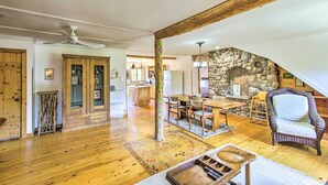 A spacious living area with wooden floors, a stone fireplace, a dining table, and a cozy seating area. - Cozy Sister Bay Getaway in Converted Barn! (Sister Bay)