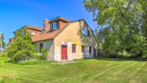 A rustic two-story house with a red door and a stone chimney. - Cozy Sister Bay Getaway in Converted Barn! (Sister Bay)