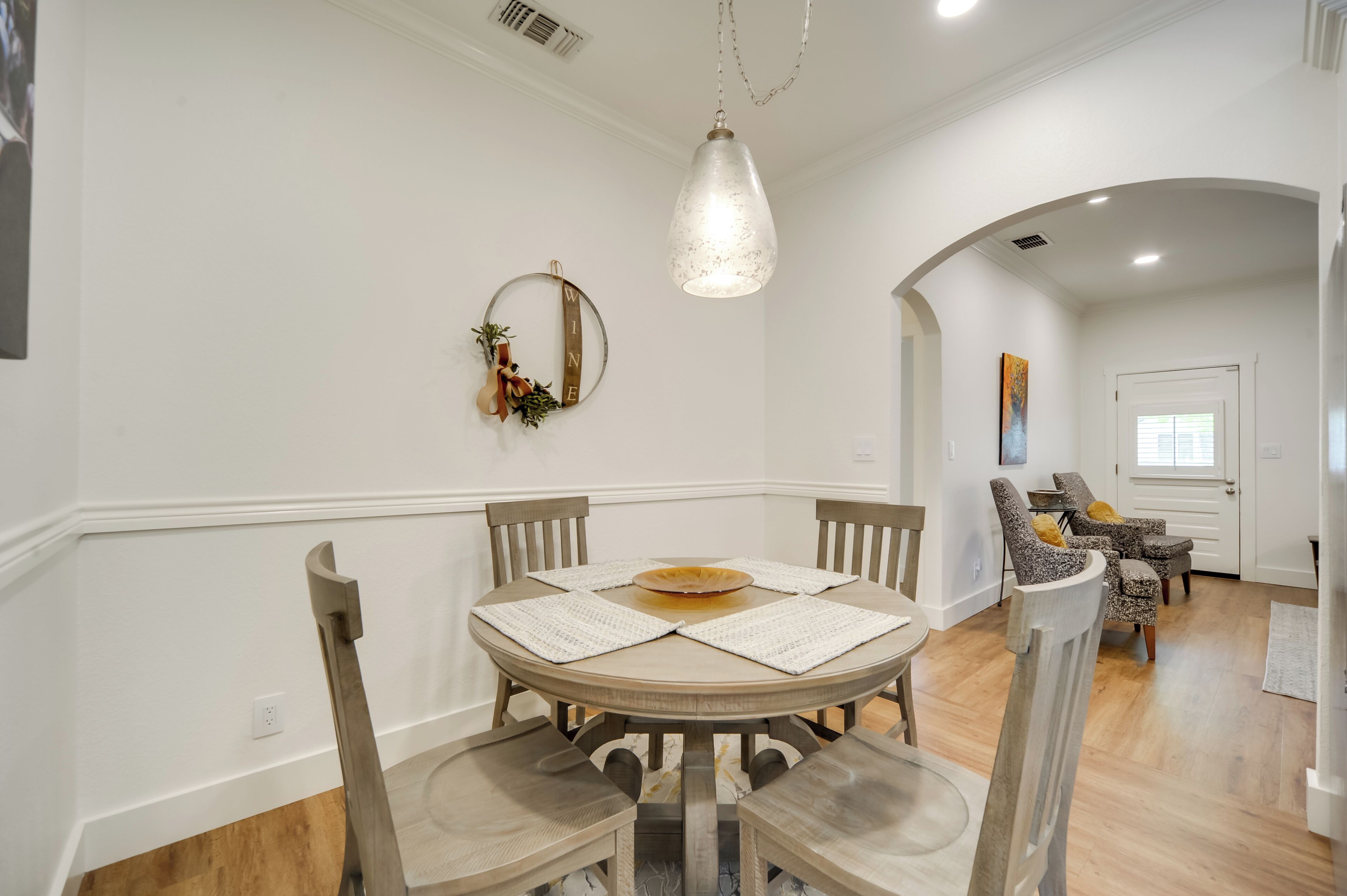 Un espace repas comprenant une table ronde, des chaises et un luminaire suspendu.