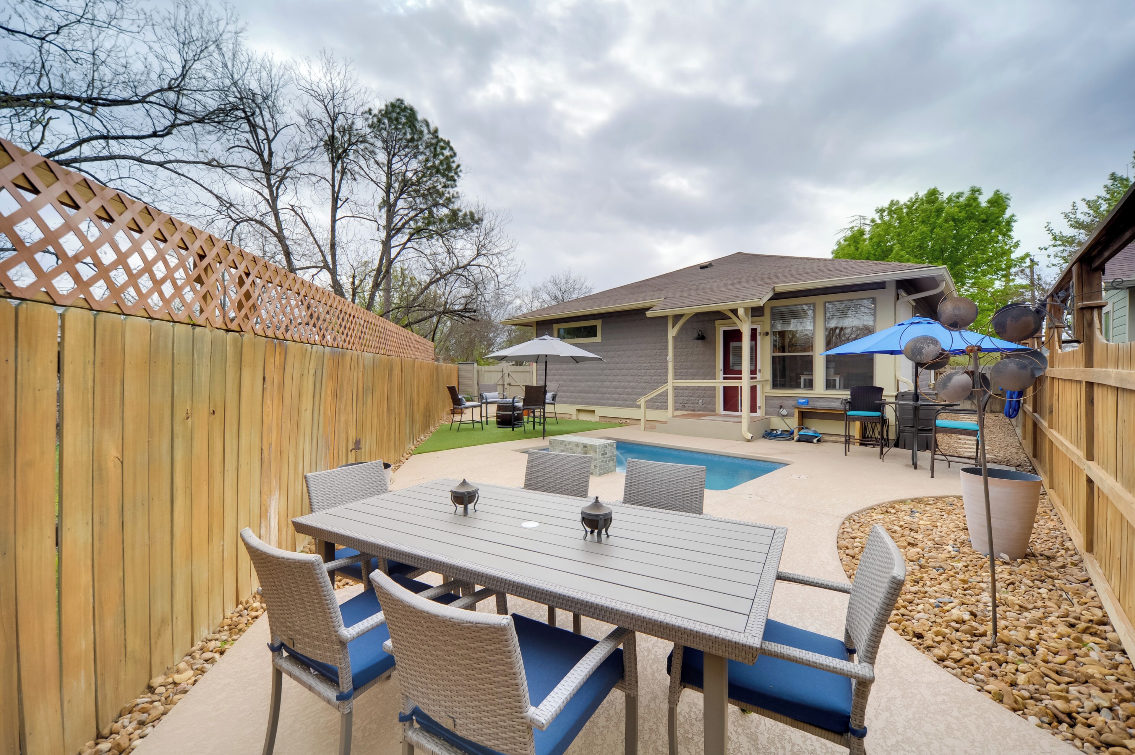 Un jardin avec une piscine, du mobilier d’extérieur et un patio couvert.