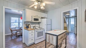 A kitchen with white cabinets, a microwave, a refrigerator, a stove, and a ceiling fan. - Tuscaloosa House 2 Mi to Coleman Coliseum! (Tuscaloosa)