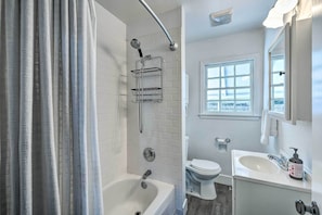 A modern bathroom with a bathtub, a shower, a toilet, and a sink. - Cozy West Sacramento Getaway w/ Private Yard! (West Sacramento)