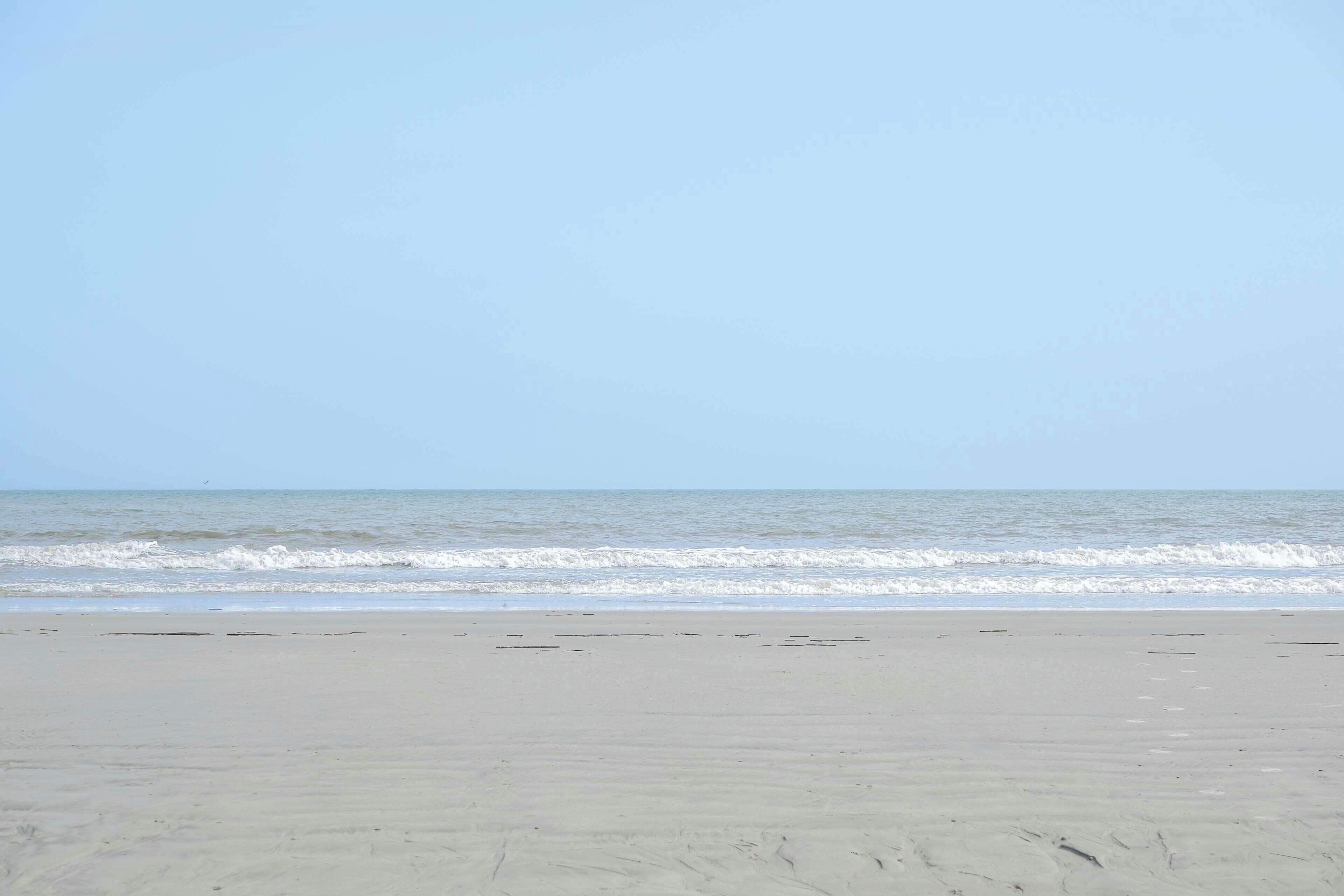 Una spiaggia con cielo sereno e mare calmo.