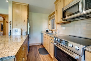 A kitchen with wooden cabinets, a stainless steel microwave, and a built-in oven. - Ski-in Breck Condo: Walk to Shops & Restaurants! (Breckenridge)