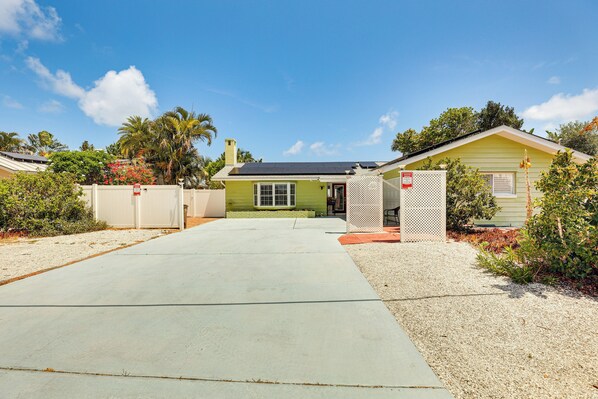A single-story house with a green exterior and a solar panel roof. - Waterfront Getaway w/ Pool & Dock - Walk to Beach! (Indian Rocks Beach)