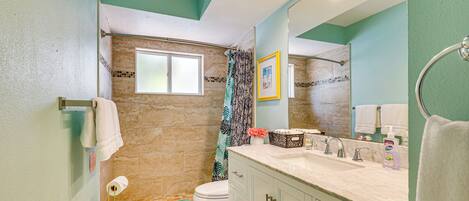 A bathroom with a toilet, sink, and shower area.