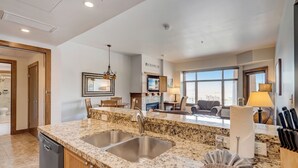 A modern kitchen with granite countertops, stainless steel sinks, and a built-in dishwasher.