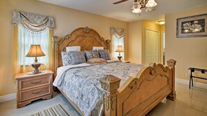 A bedroom with a wooden bed, a nightstand, a ceiling fan, and a framed picture on the wall.