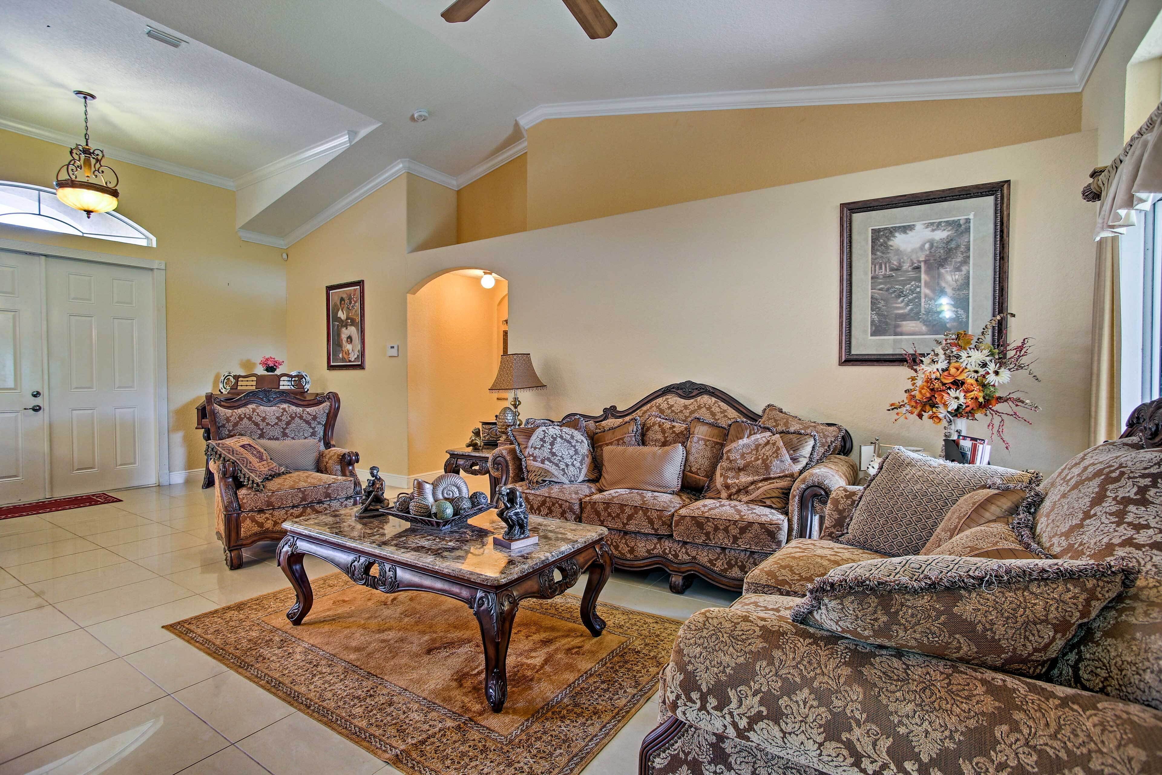 A spacious living room with a high ceiling, a large window, and a fireplace.