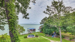 Un parque junto al lago con un parque infantil, mesas de picnic y un pabellón.