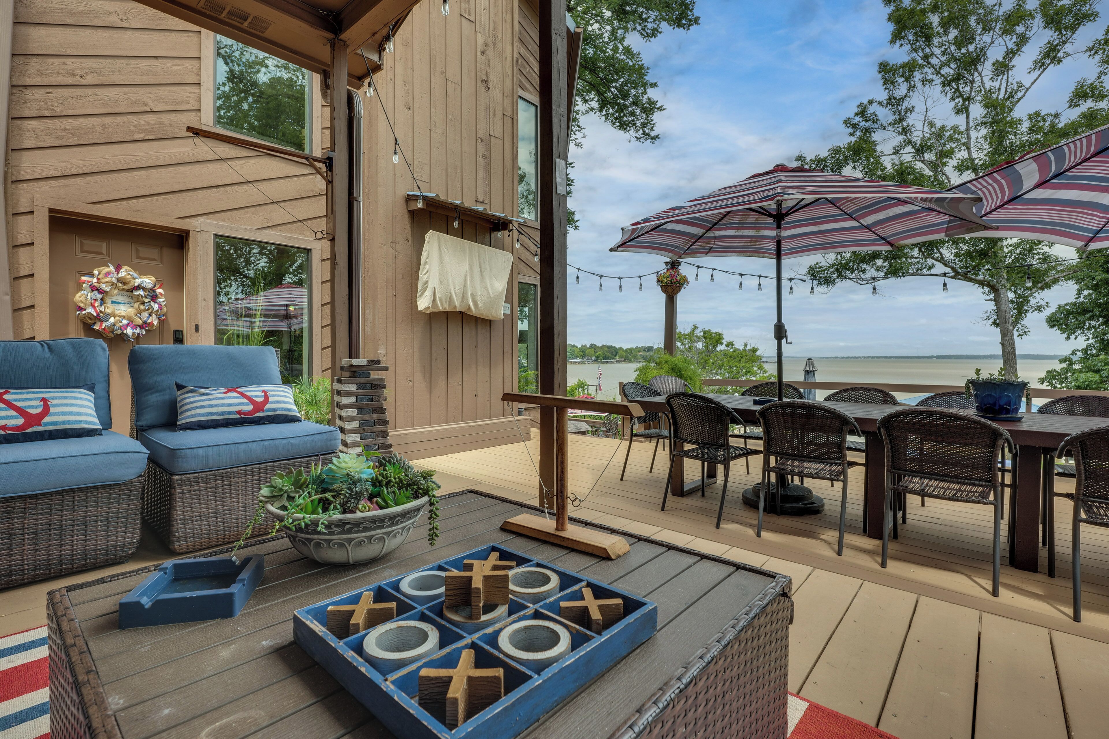 Una terraza con mobiliario exterior, una mesa y vista al agua.