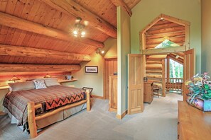 Une chambre confortable dans un chalet en rondins, avec un lit, une tête de lit en bois et un petit espace bureau.