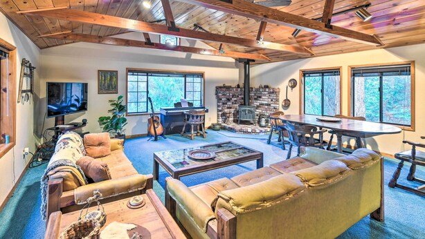 A spacious living room with a fireplace, comfortable seating, and large windows.