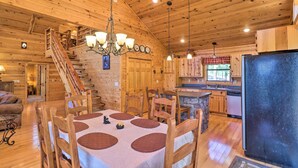 Ein Holzblockbau-Innenraum mit Essbereich, Küche und Treppe.
