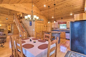 A wooden cabin interior with a dining area, kitchen, and staircase. - Peaceful Cabin w/ Deck + Scenic Mtn Views! (Melbourne)