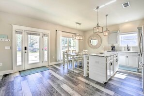 A spacious kitchen with a central island, white cabinetry, and pendant lighting. - Modern Santa Rosa Beach Retreat w/ Yard & Patio! (Santa Rosa Beach)