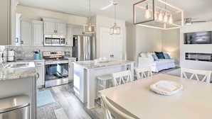 A modern kitchen with stainless steel appliances, a central island, and pendant lighting. - Modern Santa Rosa Beach Retreat w/ Yard & Patio! (Santa Rosa Beach)