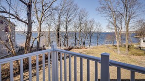 A view from a balcony overlooking a lake with bare trees and a white fence. - Renovated Family Home on Providence River! (Riverside)