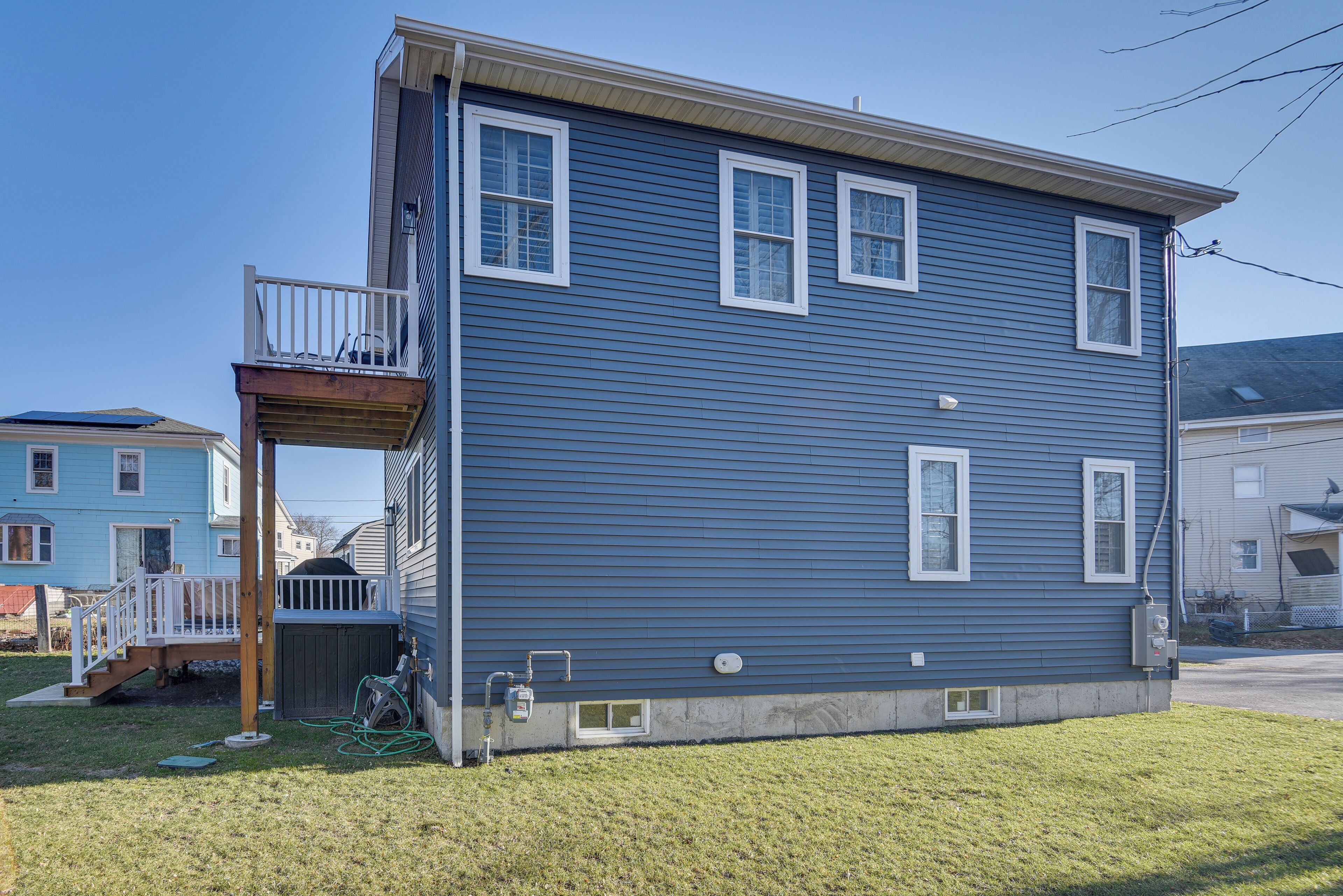 A two-story house with a balcony, a small deck, and a garage.