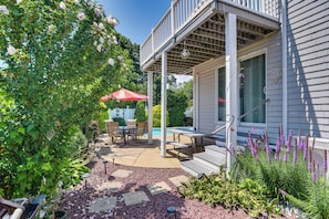 A covered patio with outdoor furniture, a pool, and a garden with purple flowers. - 3 Mi to Dtwn & Beach! Bristol Home w/ Patio (Bristol)