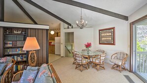 A cozy living room with a sofa, a table with chairs, a chandelier, and a bookshelf. - Woodsy Willow Creek Getaway w/ Pool & Deck! (Willow Creek)