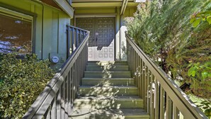 A staircase with a metal railing leading to a double door. - Woodsy Willow Creek Getaway w/ Pool & Deck! (Willow Creek)
