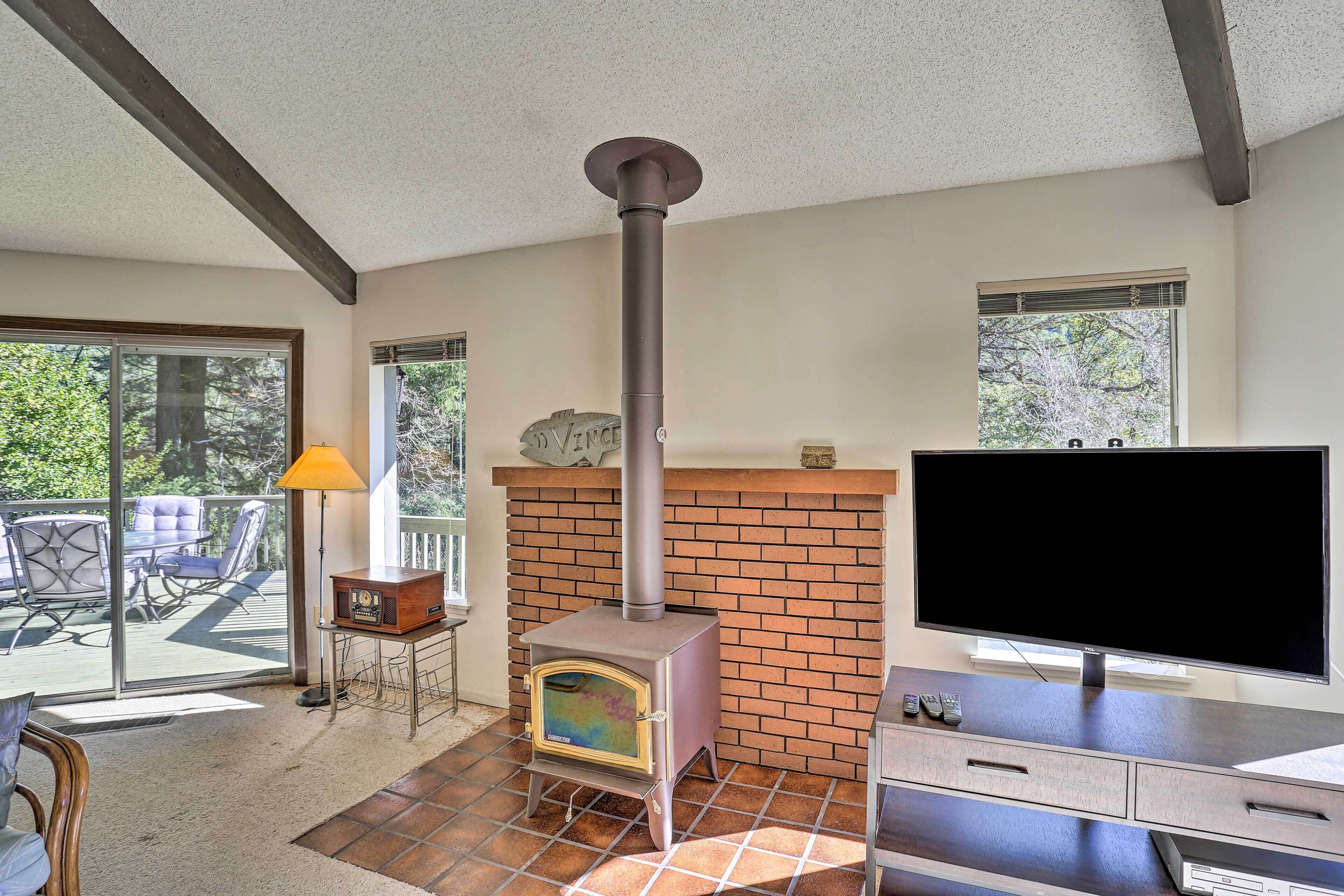 A room with a fireplace, a TV, and a patio area with outdoor furniture.