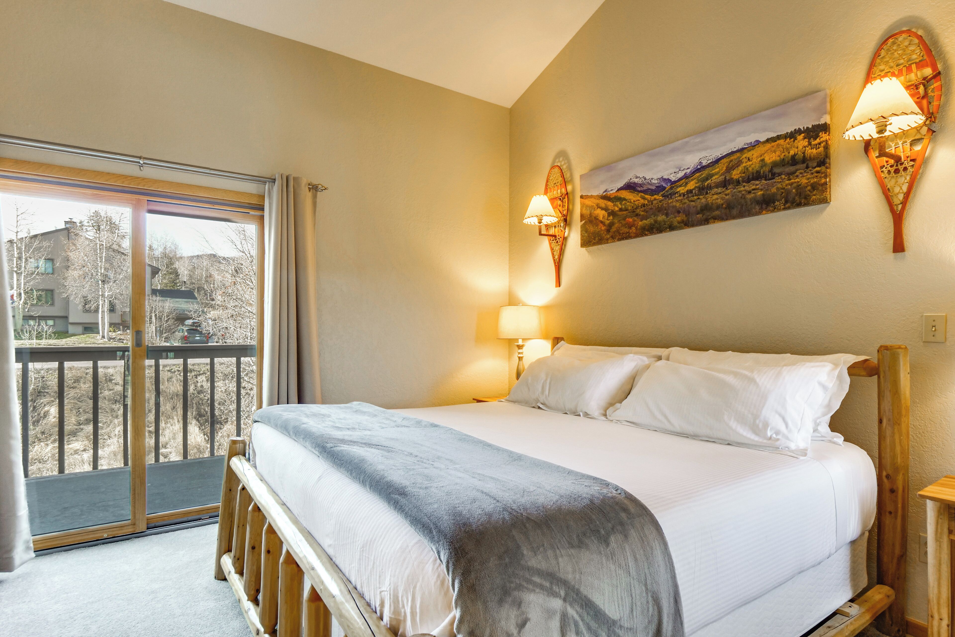 Une chambre à coucher avec un lit, un balcon et un tableau au mur.