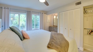 A bedroom with a large bed, a ceiling fan, a window with curtains, a dresser, and a closet with hanging clothes. - Siesta Key Condo w/ Heated Pool < 1 Mi to Beach (Siesta Key)
