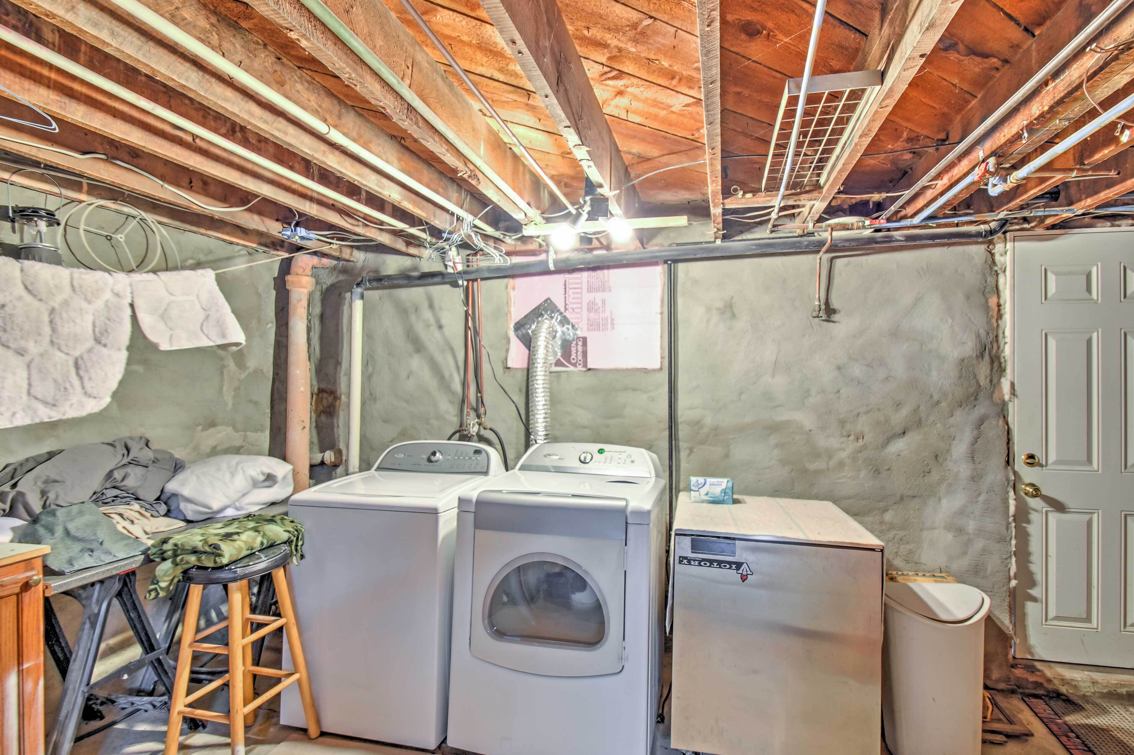 A laundry room with two washing machines, a dryer, and a small refrigerator.