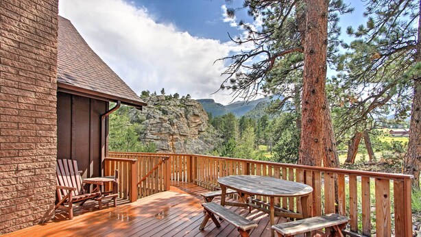 A wooden deck with a table and chairs, overlooking a mountainous landscape. - 'peaceful Pines' Estes Park Home: Longs Peak View (Estes Park)