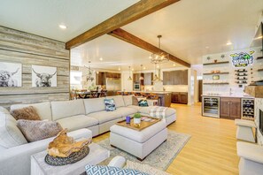 A spacious living area with a large sofa, a coffee table, and a wooden accent wall. - Stunning Home w/ Hot Tub Near Park City Skiing! (Park City)