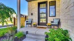 A stone building with a black door, two wicker chairs with cushions, and potted plants. - Stunning Home w/ Hot Tub Near Park City Skiing! (Park City)