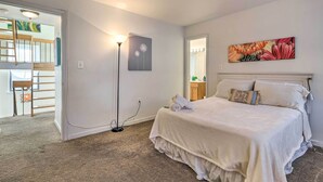 A bedroom with a bunk bed, a large painting, and a bedside lamp.